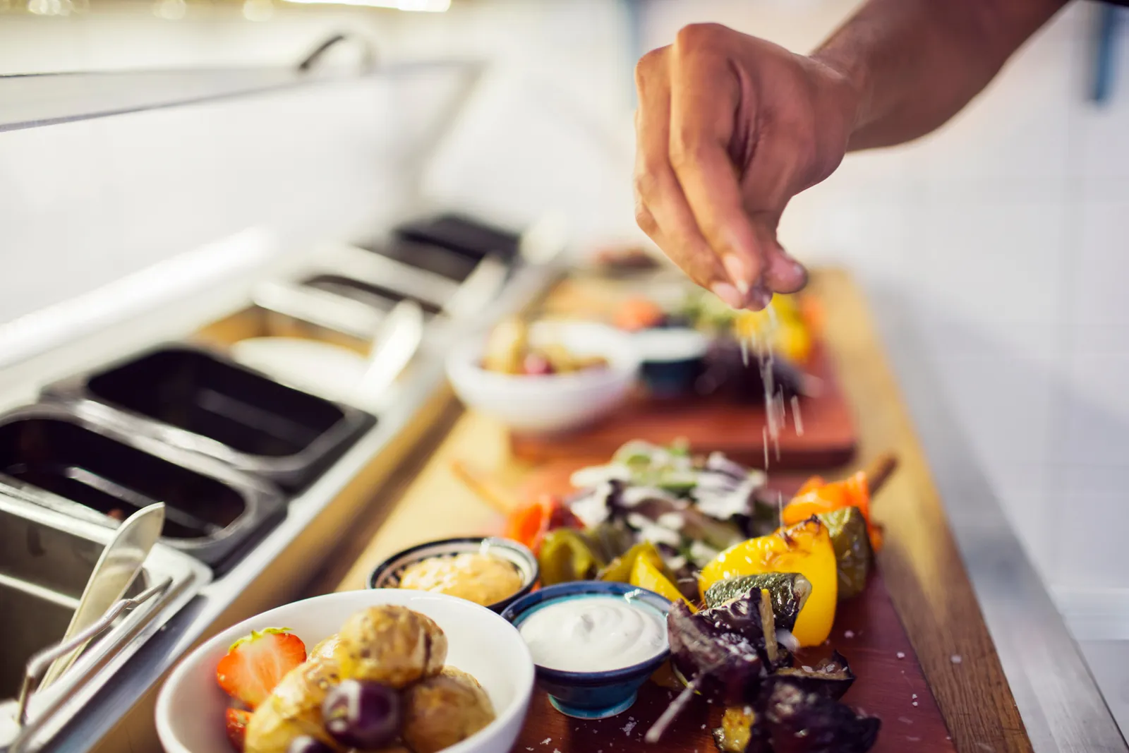 Person seasoning food at the catering van