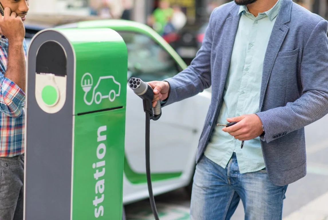 man charging electric car